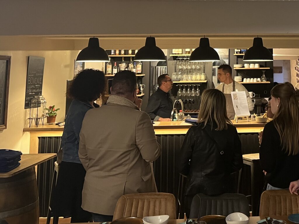 Atelier culinaire chic et élégant à Bordeaux, un chef renommé enseignant à un groupe dans une cuisine moderne avec des plats gastronomiques et une ambiance raffinée.