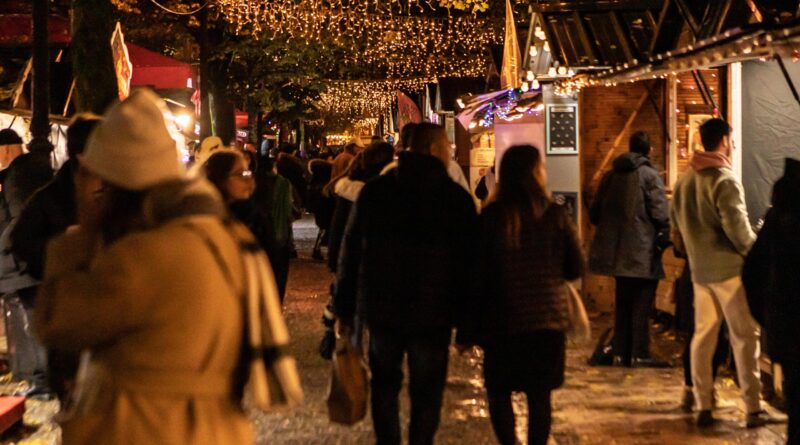 Marché de Noël à Bordeaux la nuit, avec des stands illuminés, des décorations festives et une ambiance chaleureuse sous les lumières scintillantes.